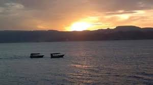 Sunset view over the southern beach of Aqaba, with vibrant colors painting the sky and calm waves gently lapping the shore.