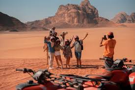 "Rock formations and stunning desert landscape in Wadi Rum, with towering sandstone mountains and golden sand dunes."