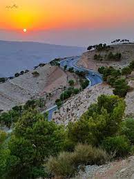 Alt Text for "رحلة الطفيلة": "A scenic view of Tafilah, Jordan, showcasing its beautiful landscapes and local culture. The image captures the serene atmosphere of the town with its mountains, traditional buildings, and peaceful environment, ideal for an overnight stay experience."