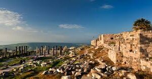 Alt Text: **An ancient view of the ruins of Umm Qais, showcasing the Roman theatre and scenic landscapes of the surrounding area, highlighting the historical significance and beauty of the site.**