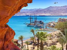 "Beautiful coastal view of Aqaba with clear blue waters, sandy beaches, and stunning mountains in the background."